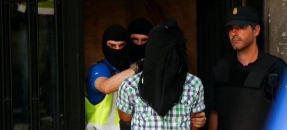 Police lead away a suspect from an apartment block during a raid in which they arrested a 32-year-old Moroccan they said was 'highly radicalised', in Madrid, June 21, 2017. REUTERS/Juan Medina