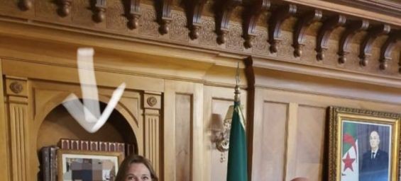 The Algerian and Swedish ambassadors standing before a blurred photo that shows King Mohammed VI and the Algerian diplomat. / DR