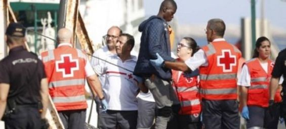Members of the Spanish Red Cross assist a man who was rescued at the port of Almeria, southern Spain./Ph. EPA/CARLOS BARBA