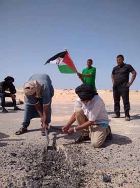 Des manifestants du Polisario arrachant des morceaux du bitume de la route à El Guerguerate. / DR