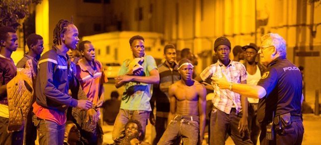 Sub-Saharan migrants listening to a police officer after crossing the border entering Ceuta on the 1st of August 2017./Ph. Jesus Moron. Reuters 