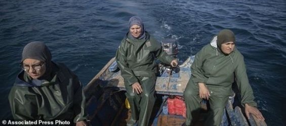 Fatiha Naji, right, Fatima Mekhnas, center and Saida Fetouh, left, members of the first Moroccan female fishing cooperative go out to sea in a fishing boat. / Mosa'ab Elshamy -AP